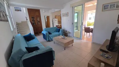 a living room with a blue couch and a table at Chrystallia Protaras in Paralimni