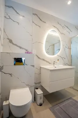 a bathroom with a toilet and a sink and a mirror at Raise Cityscape Limassol Suites in Limassol