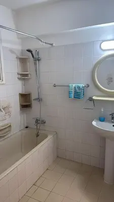 a bathroom with a bath tub and a sink at Larnaca Ancient View Rooms With Smart TV & Netflix in Larnaka