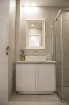 a white bathroom with a sink and a shower at STAY Glam Skin Studio in Nicosia