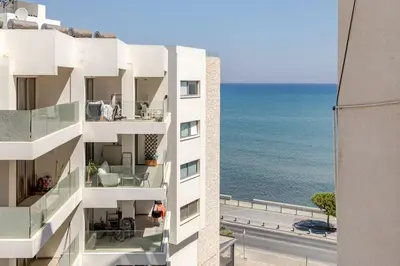 an apartment building with a view of the ocean at Kastella Blue Apartment Near Beach in Larnaka