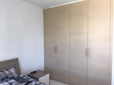 a bedroom with white cabinets and a bed at Neoptolemou Residences in Nicosia