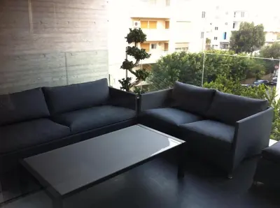 a couch and a coffee table on a balcony at Neoptolemou Residences in Nicosia