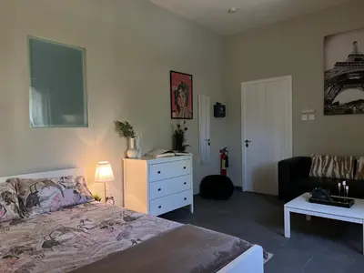 a bedroom with a bed and a dresser and a couch at Olistay in Voroklini