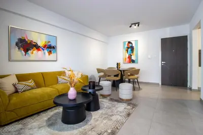 a living room with a yellow couch and tables at Modern City Retreat - Balcony and Chic Design in Nicosia