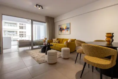 a living room with a yellow couch and a table at Modern City Retreat - Balcony and Chic Design in Nicosia