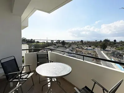 a balcony with a table and chairs and a view at Serenity in the Sun - Holiday Apt - Larnaca in Larnaka