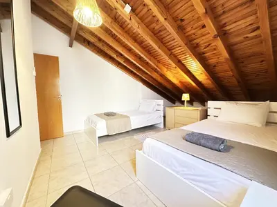 a bedroom with two beds and a wooden ceiling at Serenity in the Sun - Holiday Apt - Larnaca in Larnaka