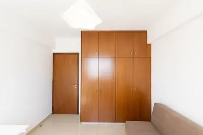a living room with wooden cabinets and a couch at Spacious & Bright Apartment with Balcony in Larnaka