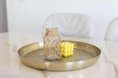 a glass bottle and yellow grapes on a plate at Spacious & Bright Apartment with Balcony in Larnaka