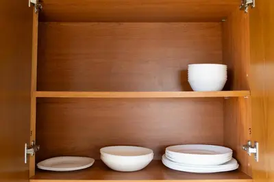 a wooden cabinet with plates and bowls in it at Spacious & Bright Apartment with Balcony in Larnaka