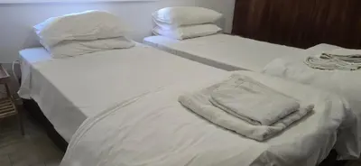 two beds with white sheets and a towel on them at Skoufa 21 - Luxury Apartment -Breakbooking CY in Limassol