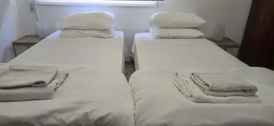 two beds in a room with white sheets and pillows at Skoufa 21 - Luxury Apartment -Breakbooking CY in Limassol