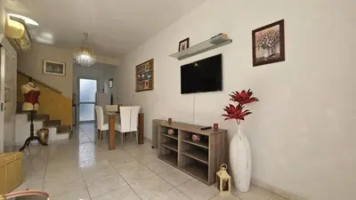 a living room with a television and a vase with a flower in it at STAY Alex's House in Strovolos