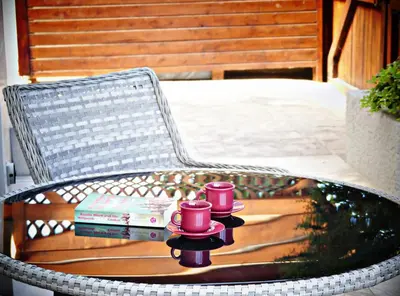 a wicker chair with two books and two coffee cups at Kyklades Resort & Spa in Paralimni