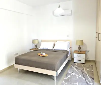 a bedroom with a bed with a tray of food on it at Kyklades Resort & Spa in Paralimni