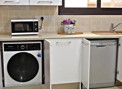 a kitchen with a microwave and a dishwasher at Kyklades Resort & Spa in Paralimni
