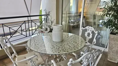 a table and chairs with a vase on a balcony at STAY Charm Classic Apartment in Strovolos