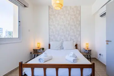 a bedroom with a bed with towels on it at Yellow Canvas - 2-BR Apartment & Balcony in Larnaca in Larnaka