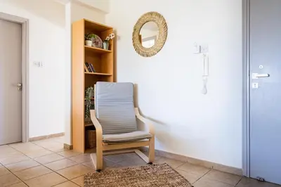 a chair sitting in a room with a mirror at Yellow Canvas - 2-BR Apartment & Balcony in Larnaca in Larnaka