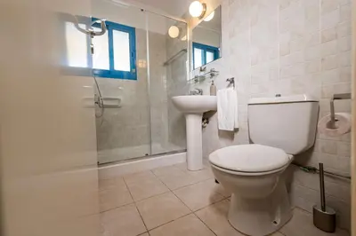 a bathroom with a toilet and a shower and a sink at Beachfront Mediterranean Escape 3bd Sea View Apartment in Pendakomo