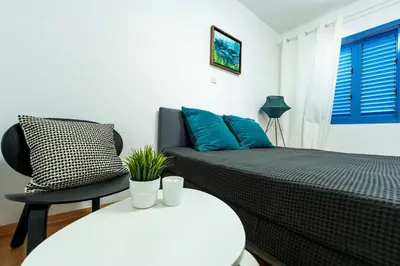 a bedroom with a bed and a chair and a table at Beachfront Mediterranean Escape 3bd Sea View Apartment in Pendakomo