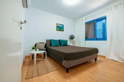 a bedroom with a bed and a table and a window at Beachfront Mediterranean Escape 3bd Sea View Apartment in Pendakomo