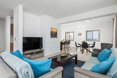 a living room with two couches and a tv at Downtown Sea View Penthouse in Larnaka