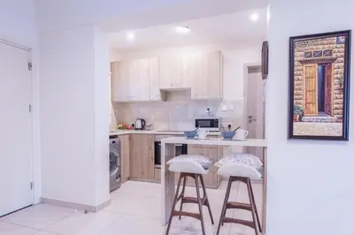 a kitchen with a counter and stools in it at Finikoudes gate in Larnaka