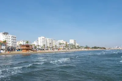 a view of a beach with buildings and the ocean at Finikoudes gate in Larnaka