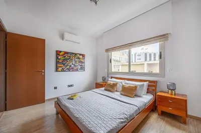 a bedroom with a large bed and a window at Lena Court - Spacious 3bdr, City Views in Limassol