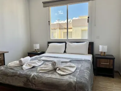 a bed with towels on it with a large window at STAY Paradise Apartment in Protaras