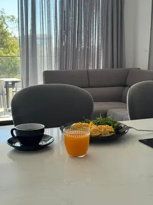 a table with a plate of food and a glass of orange juice at Hypnos Park View in Nicosia