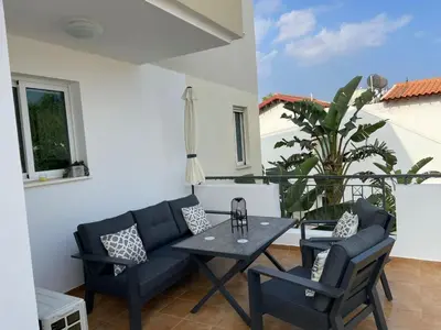 a patio with a couch and a table and chairs at Casa Luna in Paralimni