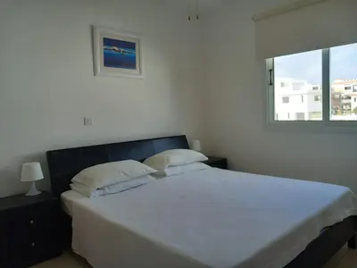 a bedroom with a large white bed with a window at Casa Luna in Paralimni