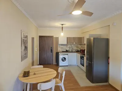 a kitchen with a table and a refrigerator at Alasia Apt-2Bdr in Nicosia