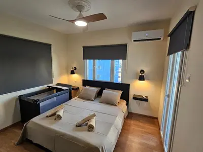 a bedroom with two beds and a large screen at Alasia Apt-2Bdr in Nicosia