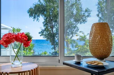 a table with a vase of red flowers and a table with a vase at Berengaria Court - Sea Views 2bdr Apartment in Limassol