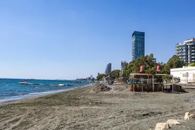 a sandy beach with buildings and the ocean at Berengaria Court - Sea Views 2bdr Apartment in Limassol