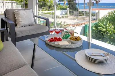 a table with a plate of food and glasses of wine at Berengaria Court - Sea Views 2bdr Apartment in Limassol