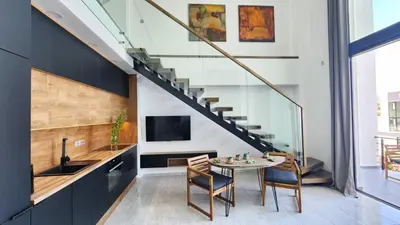 a kitchen and dining room with a table and a staircase at Idyll Homes THE PENTHOUSE in Avdhelleron