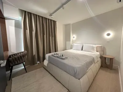 a hotel room with a bed and a chair at Idei-Eos Charming & Comfort Apartment in Nicosia
