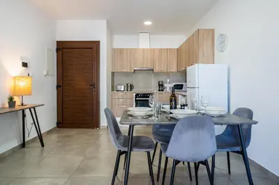 a kitchen with a table with chairs and a refrigerator at Hilltop 2-Bedroom Apartment in Larnaka