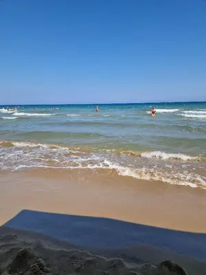 a beach with people swimming in the ocean at Grand Shapphire 4 apartments SEA VIEW in Paralimni