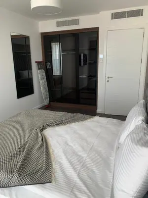 a white bed in a room with a door at Grand Shapphire 4 apartments SEA VIEW in Paralimni
