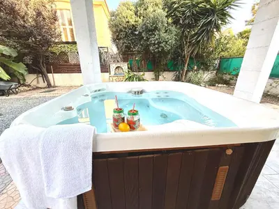a jacuzzi tub with two drinks in it at Onyx Beach Villa - Cozy 2BR - Walk to Beach in Meneou