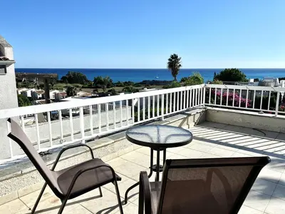 a patio with a table and chairs on a balcony at STAY Agapi Sea view Villa in Pissouri