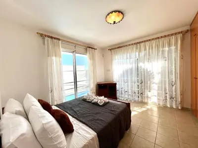 a bedroom with a bed and a large window at STAY Agapi Sea view Villa in Pissouri