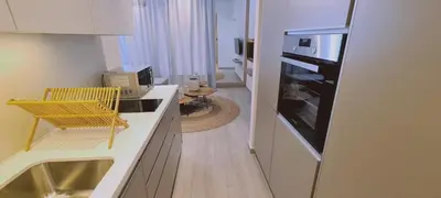 a kitchen with a yellow chair and a microwave at Amalfi Suite at Mythical Sands Resort in Paralimni