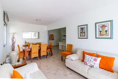 a living room with a couch and a dining room at Family Friendly 2-Bed on Limassol Seafront in Limassol